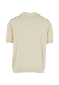 Polo en maille beige à manches courtes avec col, poignets et ourlet côtelés, vu de dos sur fond blanc.