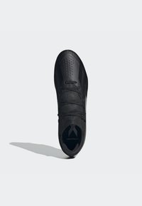Scarpe sportive nere con un design elegante, tomaia in maglia texturizzata, area delle dita perforata e lacci piatti, con un marchio discreto sulla suola.