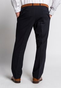 Marineblaue Hose mit maßgeschneidertem Schnitt, ausgestattet mit Gesäßtaschen und einem braunen Leder-Gürtel. Glattes Material mit einem dezenten Glanz.