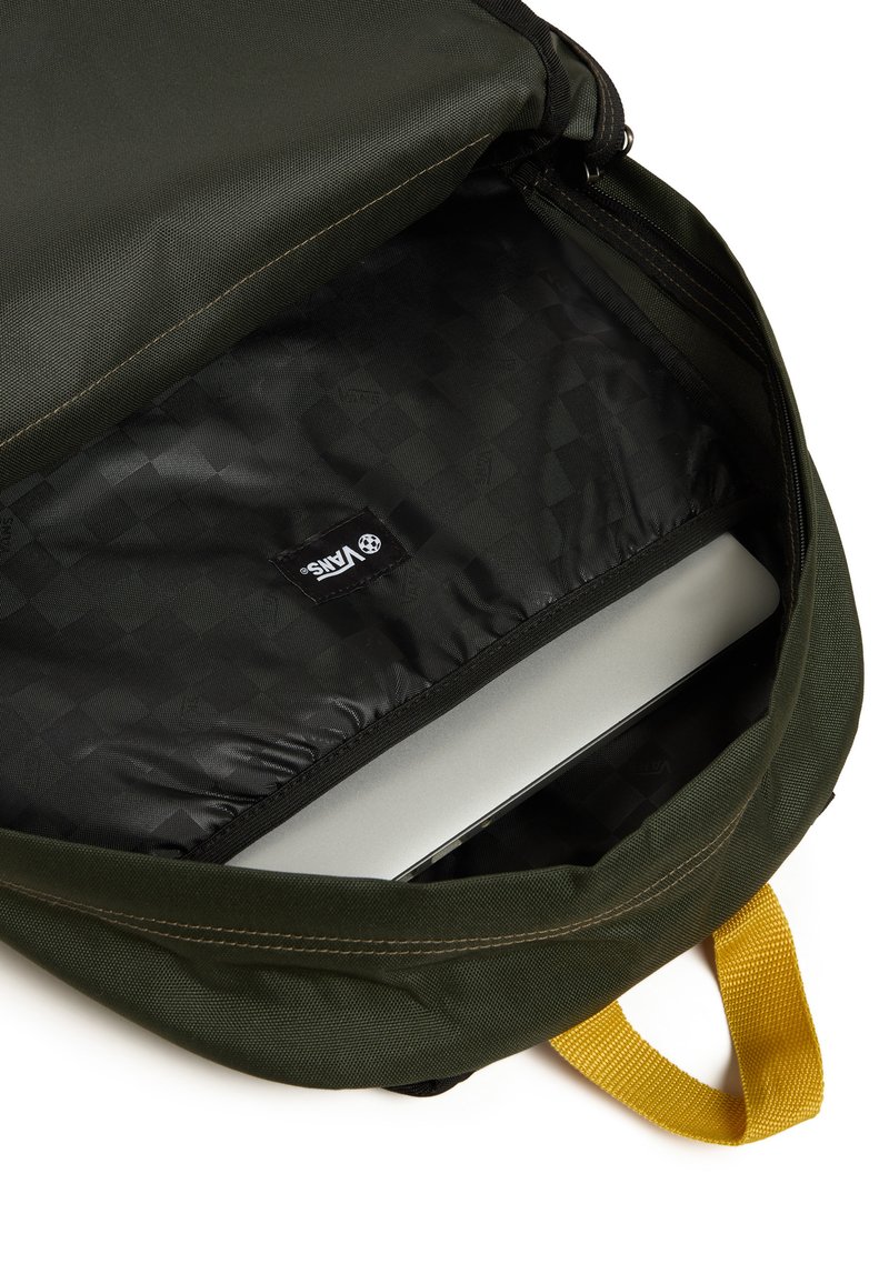 Interior de mochila de tela verde, que presenta un compartimento forrado en negro con una computadora portátil gris visible y un asa de transporte amarilla.