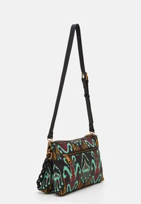 Sac en bandoulière en tissu avec un motif abstrait coloré. Sangle noire avec quincaillerie dorée et accent en chaîne texturée.