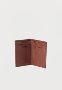 Καφέ δερμάτινο πορτοφόλι με μινιμαλιστικό σχεδιασμό, διαθέτοντας πολλαπλές θήκες για κάρτες, καθαρές ακμές και ανάγλυφη λεπτομέρεια λογότυπου.