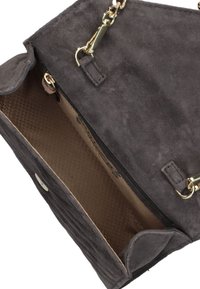Grijze suède handtas met een textuur aan de buitenkant, hardware in goudkleur, een ritsvak en een gladde beige voering aan de binnenkant.