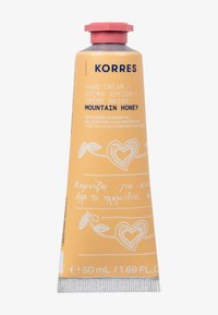 Tubo di crema per le mani Korres con un design giallo-arancio, materiale in alluminio, tappo rosa e illustrazioni bianche, etichettato "Miele di Montagna." 50 mL.