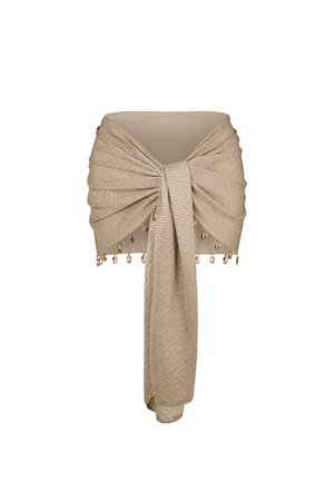 Jupe en tissu texturé beige avec des plis, nouée à l'avant, ornée de petits pendentifs en or pendants le long de l'ourlet.
