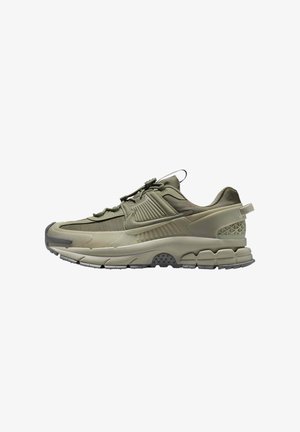 Olive green sneakers with a textured upper, mesh accents, and a chunky sole featuring tread pattern and pronounced heel support.