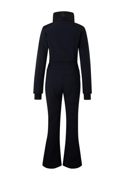 Námořnicky modrý lyžařský overal s přiléhavým střihem, dlouhými rukávy, vysokým límcem a rozšířenými nohavicemi. Vyrobený z hladké, elastické látky s bezešvými detaily.