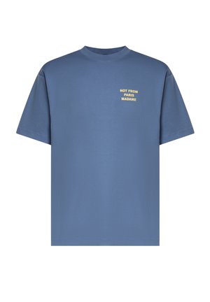 T-shirt bleu à manches courtes avec col rond et texte jaune sur la poitrine gauche indiquant "NOT FROM PARIS MADAME".