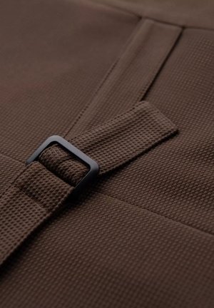 Brown textured fabric with a woven pattern, featuring a black rectangular buckle securing a strap. The material appears durable and sturdy.