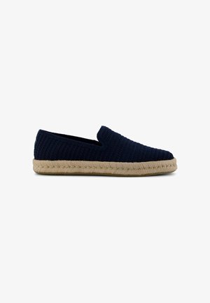 Marineblauwe gebreide slip-on espadrille met beige gevlochten koordzool en lage hak, zijaanzicht op witte achtergrond.
