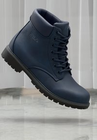 Botte de cheville en cuir bleu marine avec bout rond, col rembourré et lacets. Dotée d'une semelle extérieure en caoutchouc noir robuste. Logo de la marque sur le côté.