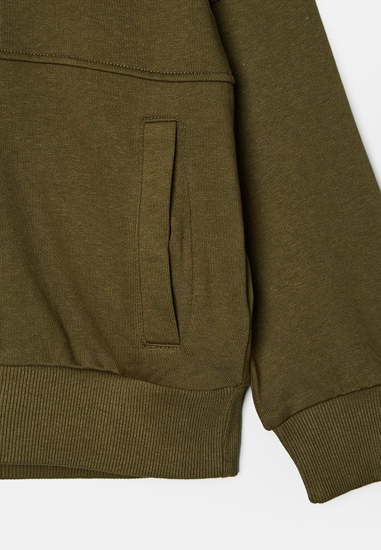 Oliwkowy sweter z ribbowym dołem, długimi rękawami i boczną kieszenią, charakteryzujący się gładką teksturą materiału i bezszwowym designem.