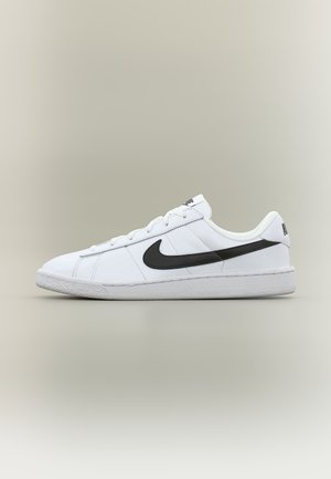Biely nízky teniska Nike s čiernym logom Swoosh, bielymi šnúrkami a textúrovanou podrážkou na neutrálnom pozadí.
