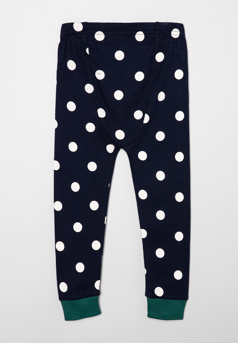 Leggings bleu marine avec des pois blancs, texture côtelée, presentant un revers vert à la cheville et une taille élastique.