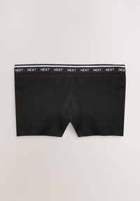 Fekete férfi boxeralsó, márkázott elasztikus derékpánttal, amely fehérrel ismétli a „NEXT” szót fekete háttéren.