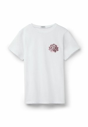 Camiseta blanca de manga corta con diseño de concha pequeña de lentejuelas rosas y negras en el lado izquierdo del pecho, fondo liso.