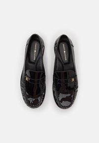 Mustad lakknahast loafers, millel on ümar varvas, punumiskaunistus ja kuldne logo detail esiosal, beežil sisetallal.