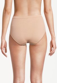 Culotte taille haute beige en mélange de coton avec des bords sans coutures, texture douce et couverture arrière minimale, vue de dos.