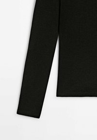 Maglia a maniche lunghe nera a costine con design aderente, texture liscia e orlo inferiore rifinito con dettagli di cuciture minime.