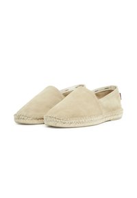 Bež suède espadrile s okruglim vrhom, pletenom jute potplatom i minimalističkim dizajnom. Slip-on stil bez vidljivih metalnih dijelova.