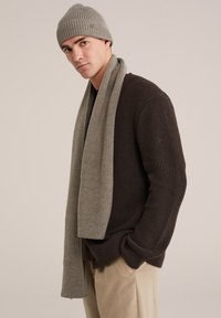 Tmavě hnědý pletený svetr, světle šed�ý pletený šál a odpovídající čepice; všechny mají žebrovanou strukturu a jednoduchý design.