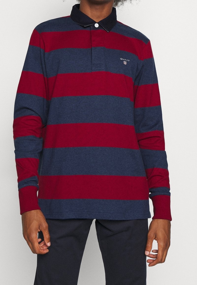 Langärmliges Polohemd mit horizontalen Streifen in Marineblau und Burgunderrot, einem dunklen Kragen und einem gestickten Logo auf der Brust. Baumwollstoff.