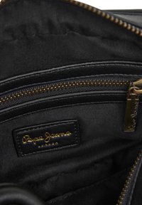 Črno tkaninsko notranjost torbe z zlatim logotipom Pepe Jeans London in zlatim zadrževalnim obročkom na delno odprtem žepu z zadrgo.