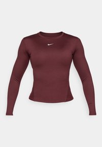 Burgundska dugouga majica sa dugim rukavima sportskog kroja, izrađena od glatkog materijala. Sadrži mali bijeli Nike logo na prsima.
