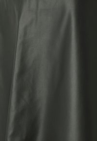 Tessuto in pelle nera con una finitura liscia, che mostra leggere pieghe e rughe, suggerendo flessibilità e durata.