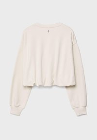 Sweat court couleur crème avec manches longues et poignets côtelés, présenté à plat avec le dos visible et un petit logo centré près de l'encolure.