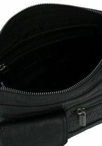 Sac à main en cuir noir avec texture crocodile, doté d'une fermeture éclair et d'une poche intérieure. Doublure intérieure lisse.