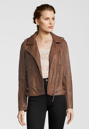Braune Leder-Bikerjacke mit Reißverschlussfront, Schulterklappen und Reißverschlusstaschen, kombiniert mit einem hellen Grafik-T-Shirt und schwarzen Jeans.