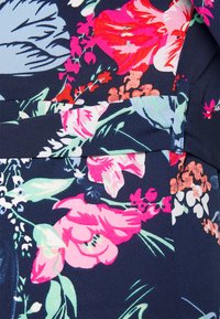 Tecido floral com um fundo azul-marinho, adornado com flores coloridas em rosa, vermelho e verde. Textura suave com um brilho sutil.