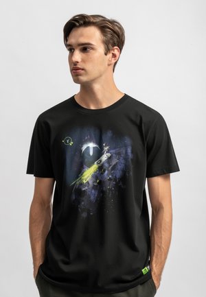 T-shirt nera in cotone con una grafica colorata a tema spaziale che presenta pianeti, stelle e un design di una cometa. Maniche corte e collo a giro.