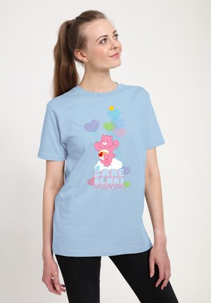 Lyseblå bomulds t-shirt med et pink Care Bear-tryk, farverige balloner og hjerteaccentuer, samt teksten "CARE BEARS FOREVER."