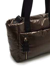 Bruine puffer tote bag met zwarte webbandhandvaten, met een ritszak aan de voorkant en een glanzende, gewatteerde textuur.
