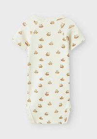 Ljusgrön onesie med korta ärmar, prydd med ett upprepat brunt båt mönster. Tillverkad av ribbat tyg med rund halsringning.