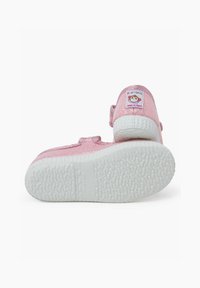 Rosa Glitzer-Sneaker mit Klettverschluss, strukturierten weißen Gummisohle und einem Smiley-Gesicht-Label an der Ferse. Reflektierende Oberfläche.