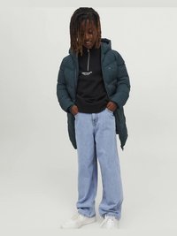 Tumeroheline kapuutsiga turske talvejope, must lukuga dressipluus logoga, helesinised teksapüksid ja valged tossud. Tekstuuriga kangas, lõdva istuvusega.