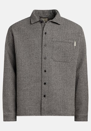 Black and white checkered button-up shirt with a left chest pocket, classic collar, and a textured fabric. Black buttons on the front.