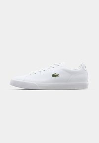 Adidași albi din material sintetic. Prezintă un design cu vârf jos, închidere cu șireturi, talpă texturată și un logo verde de crocodil pe lateral.