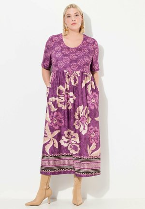 Lila Blumendruckkleid mit kurzen Ärmeln, lockerer Passform und Taschen. Mit einem gemusterten Saum in rosa und schwarzen Akzenten. Glatte Stofftextur.