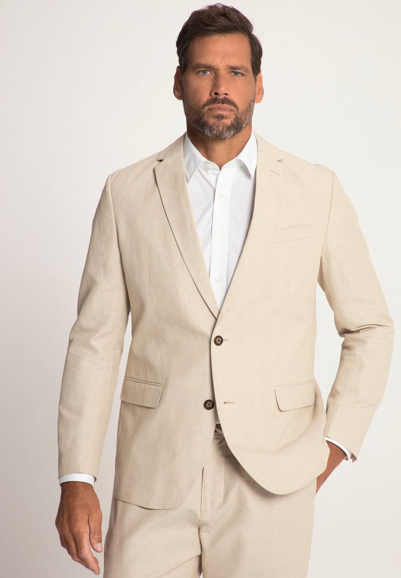 Beige Leinenanzugjacke mit einem eingefassten Revers, zwei Knöpfen und Seitentaschen. Getragen über einem weißen Hemd mit Knopfleiste, das eine glatte Textur aufweist.