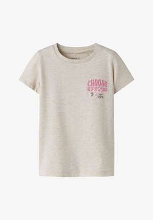 Beżowy t-shirt z krótkim rękawem i okrągłym dekoltem, z różowym napisem „Choose Kindness” oraz małą grafiką kwiatu po lewej górnej stronie.