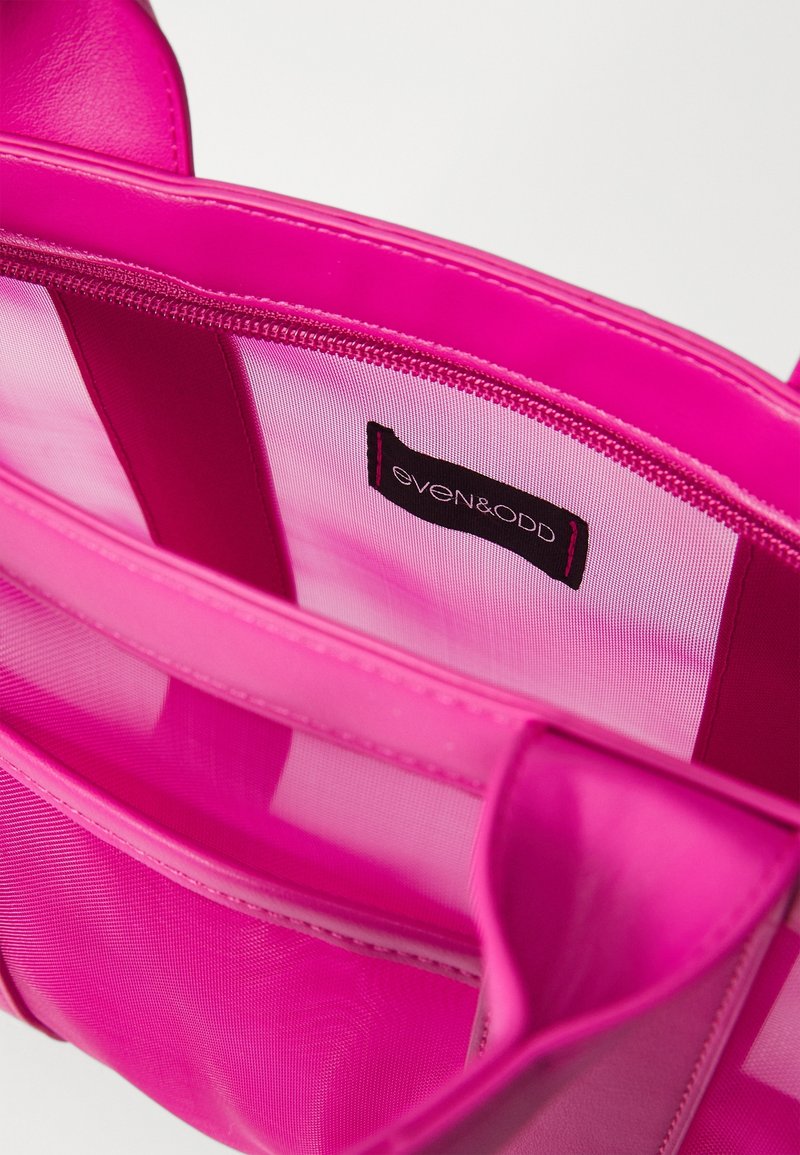 Rosa strukturerad handväska i slät konstläder med mesh-foder, försedd med flera inre fack och en even&odd-etikett.