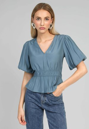 Blouse bleue à manches courtes avec un décolleté en V, des manches bouffantes et une taille froncée. Tissu lisse avec une coupe décontractée et un ourlet peplum.