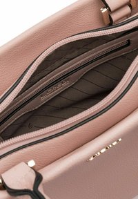 Rosa Lederhandtasche mit einem Innenraum, der über organisierte Fächer, eine Reißverschlusstasche und ein gestreiftes Stofffutter mit Markenlogo verfügt.