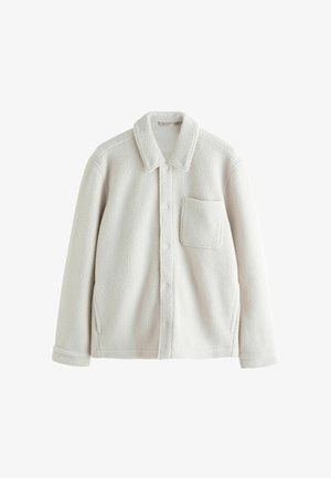 Gaiši pelēka, mīksta flīsa jaka ar apkaklīti, priekšējiem pogām, vienu krūšu kabatu un sānu šķēlumiem ērtībai.