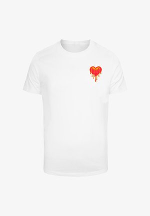 Biela bavlnená tričko s červeným a žltým srdcom s kvapkajúcim dizajnom na ľavej strane hrudníka. Krátke rukávy a okrúhly výstrih.