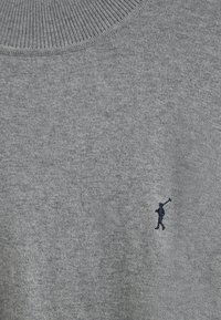 Pull en maille gris clair avec un col côtelé et un petit logo en broderie marine représentant une personne tenant un bâton sur le côté inférieur gauche.